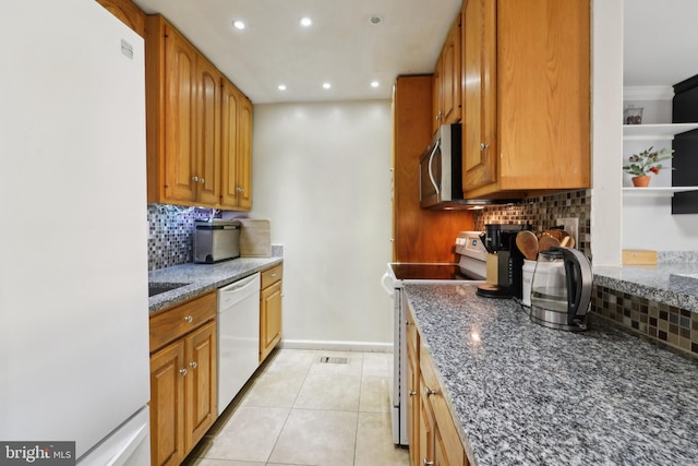 kitchen with white appliances, light tile patterned floors, decorative backsplash, dark stone countertops, and recessed lighting