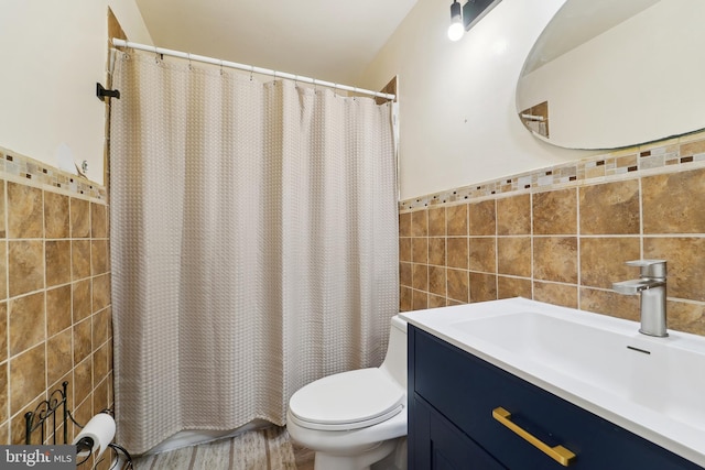 full bathroom featuring toilet, wainscoting, vanity, and tile walls