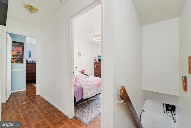 corridor featuring an upstairs landing and baseboards