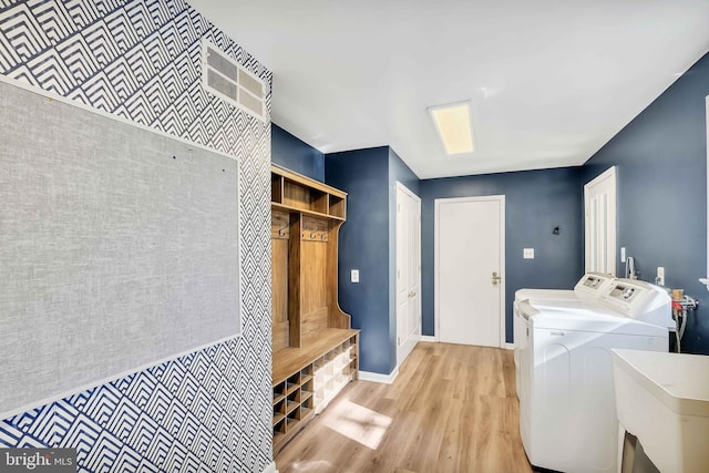 laundry area featuring sink, washing machine and dryer, and light wood-type flooring