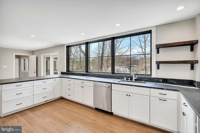 kitchen featuring white cabinetry, sink, stainless steel dishwasher, a healthy amount of sunlight, and light wood-type flooring