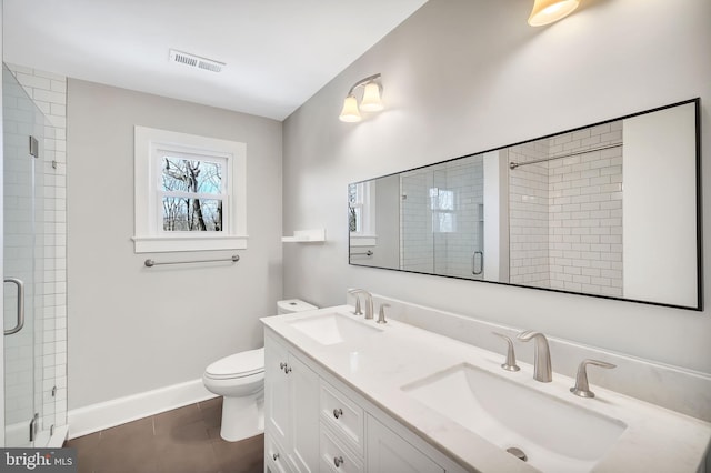 bathroom with vanity, toilet, a shower with shower door, and tile patterned flooring