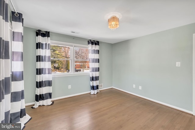 unfurnished room with hardwood / wood-style flooring