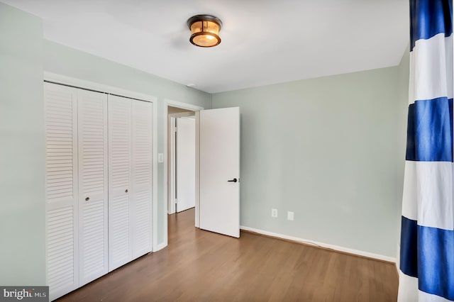 unfurnished bedroom featuring hardwood / wood-style floors and a closet