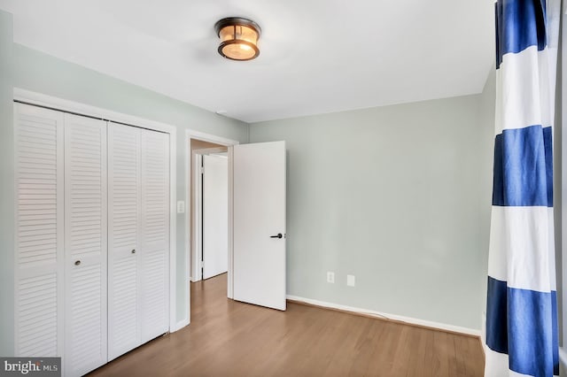 unfurnished bedroom featuring hardwood / wood-style flooring and a closet