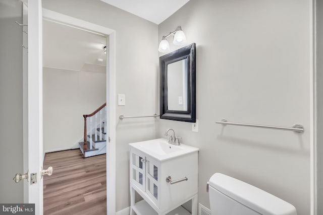 bathroom featuring vanity, hardwood / wood-style flooring, and toilet