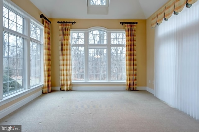 carpeted empty room with vaulted ceiling