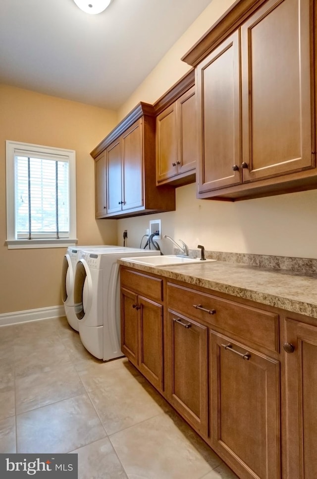 laundry area with cabinets, washer and clothes dryer, and light tile patterned floors