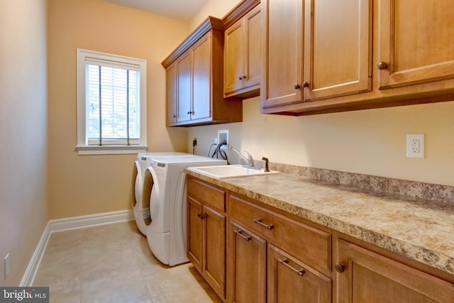 washroom with sink, washing machine and dryer, and cabinets