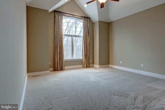 empty room featuring ceiling fan, light colored carpet, and vaulted ceiling