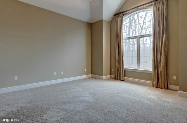 carpeted spare room featuring vaulted ceiling and a healthy amount of sunlight