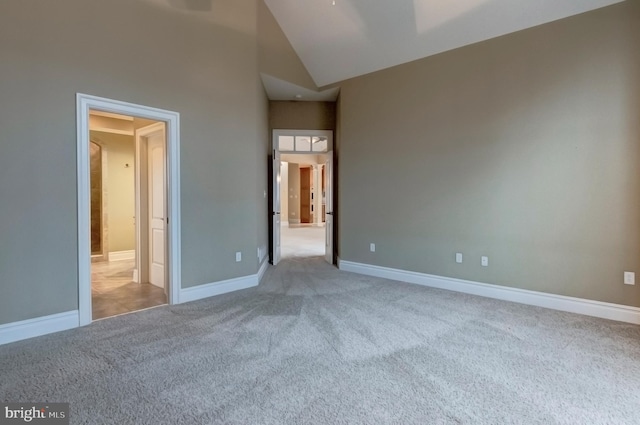 unfurnished bedroom with light carpet and a towering ceiling