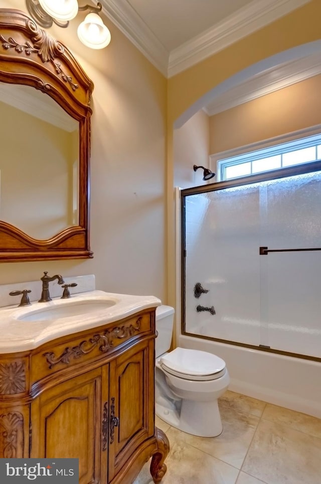 full bathroom with shower / bath combination with glass door, tile patterned flooring, ornamental molding, vanity, and toilet