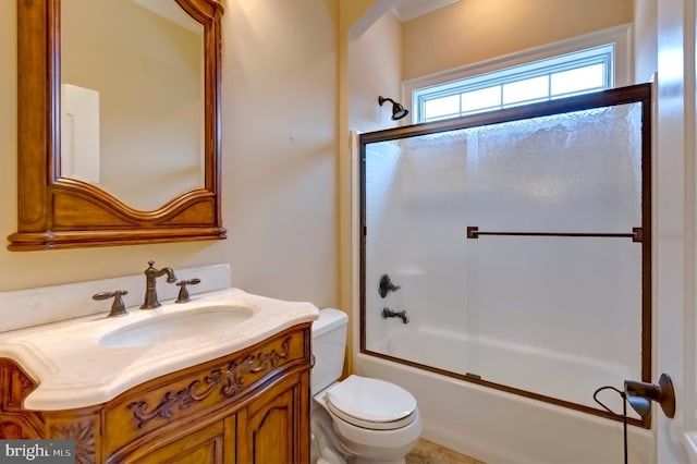 full bathroom featuring vanity, shower / bath combination with glass door, and toilet