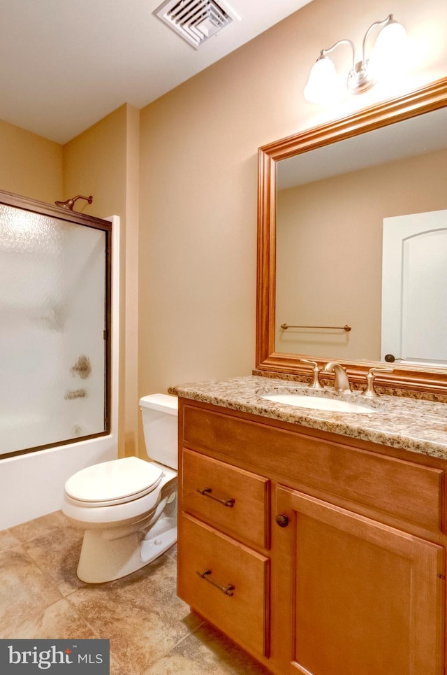 full bathroom featuring vanity, toilet, and bath / shower combo with glass door