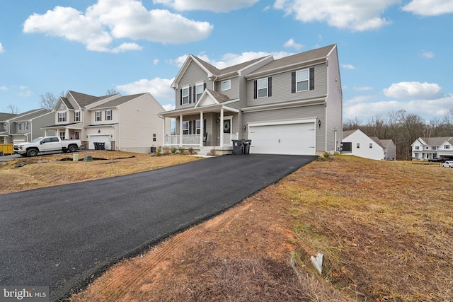 view of front of property with a porch, a garage, and a front lawn