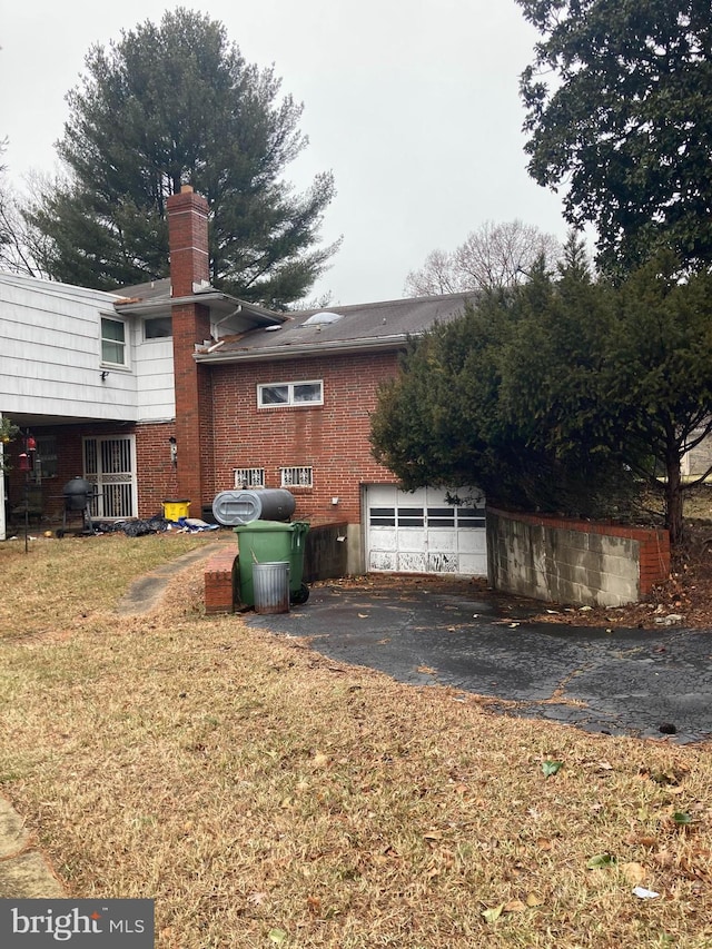 view of home's exterior with a garage and a lawn