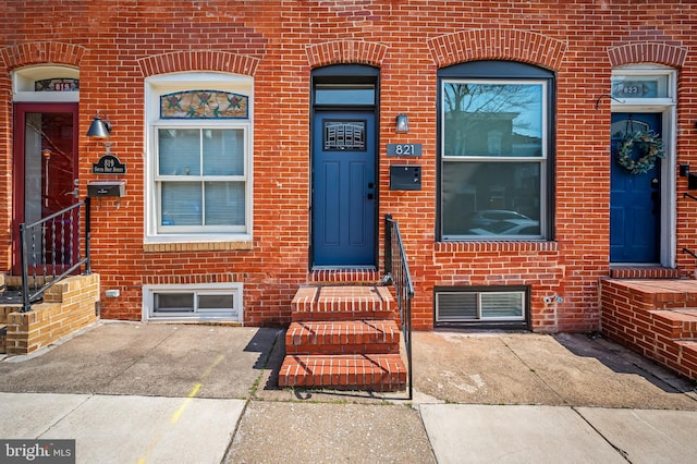 doorway to property with brick siding