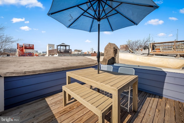 wooden terrace featuring outdoor dining area and a fireplace