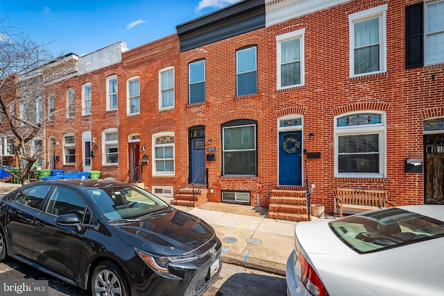 townhome / multi-family property with entry steps and brick siding