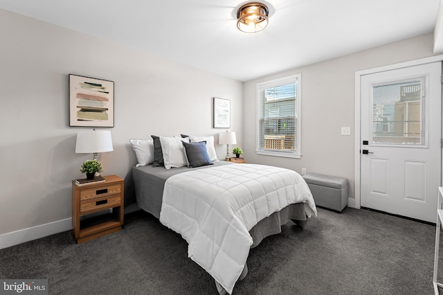 bedroom featuring dark carpet and baseboards