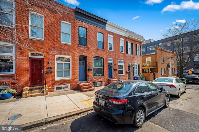 townhome / multi-family property with entry steps and brick siding