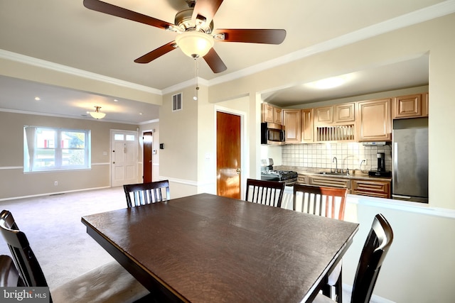 unfurnished dining area featuring a sink, ornamental molding, visible vents, baseboards, and light carpet