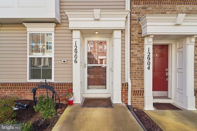 doorway to property featuring brick siding