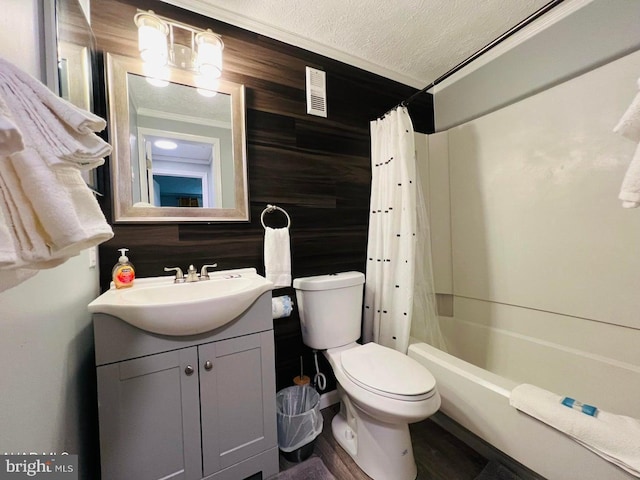 full bathroom with wood walls, vanity, toilet, shower / bathtub combination with curtain, and a textured ceiling