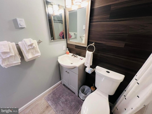 bathroom with vanity, wood-type flooring, and toilet