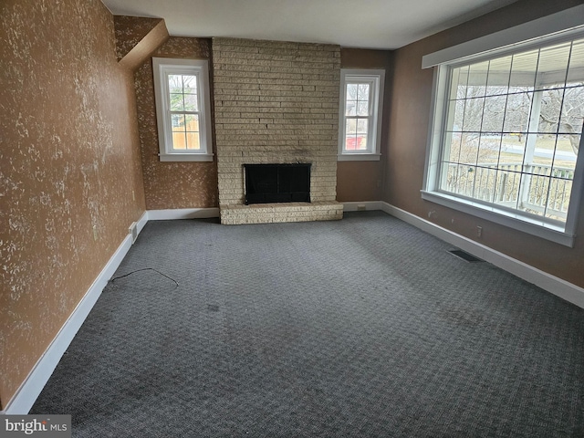 unfurnished living room with a brick fireplace and carpet