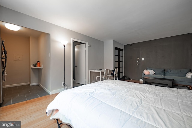 bedroom with baseboards and wood finished floors