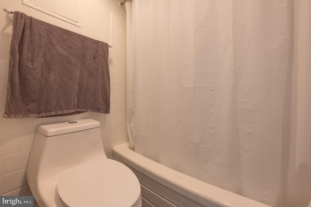 bathroom featuring shower / tub combo with curtain and toilet