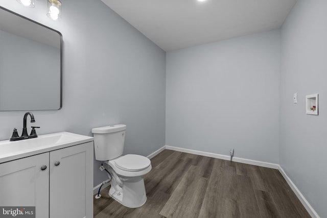 bathroom with hardwood / wood-style flooring, vanity, and toilet