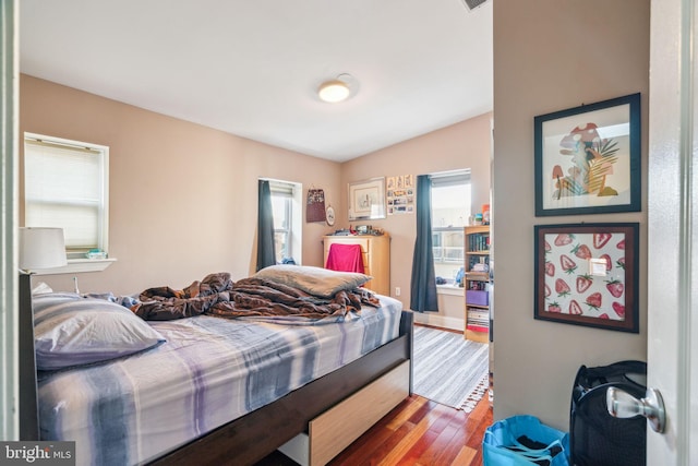 bedroom with lofted ceiling and wood finished floors