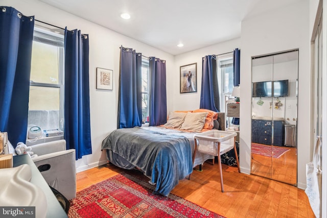 bedroom with baseboards, wood finished floors, and recessed lighting