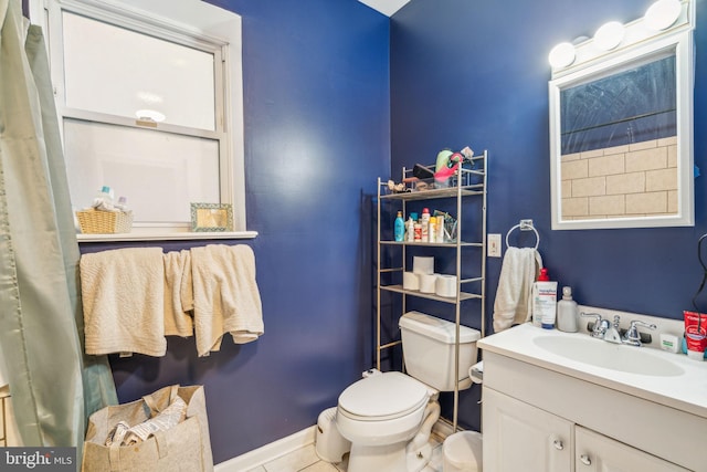 bathroom with toilet, tile patterned flooring, vanity, and baseboards