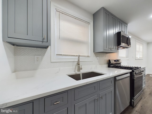 kitchen with gray cabinets, tasteful backsplash, appliances with stainless steel finishes, and sink