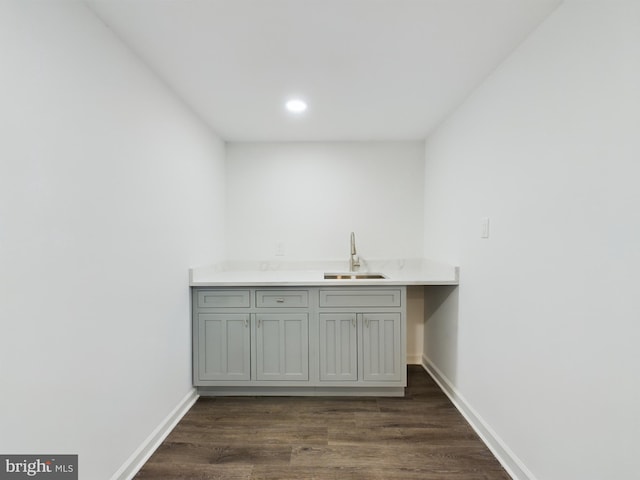 clothes washing area featuring sink and dark hardwood / wood-style floors