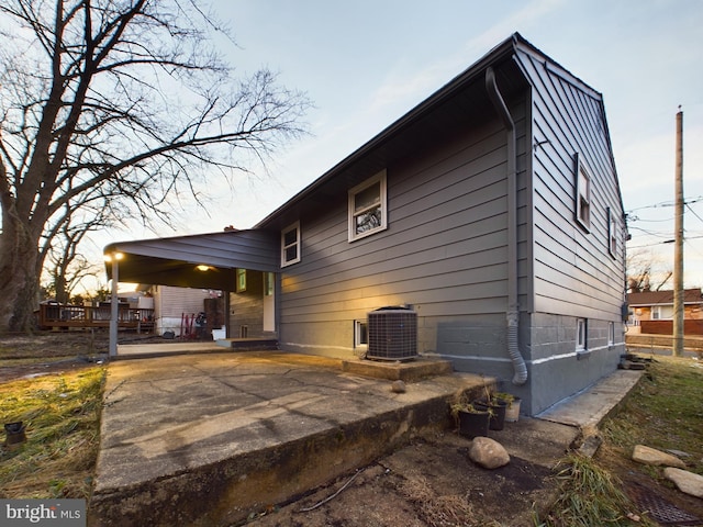 back house at dusk with a patio and central air condition unit