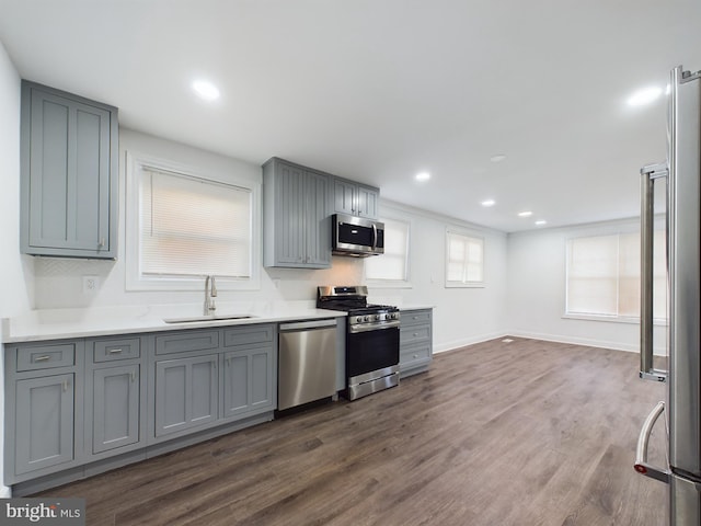 kitchen with dark hardwood / wood-style flooring, sink, gray cabinets, and stainless steel appliances