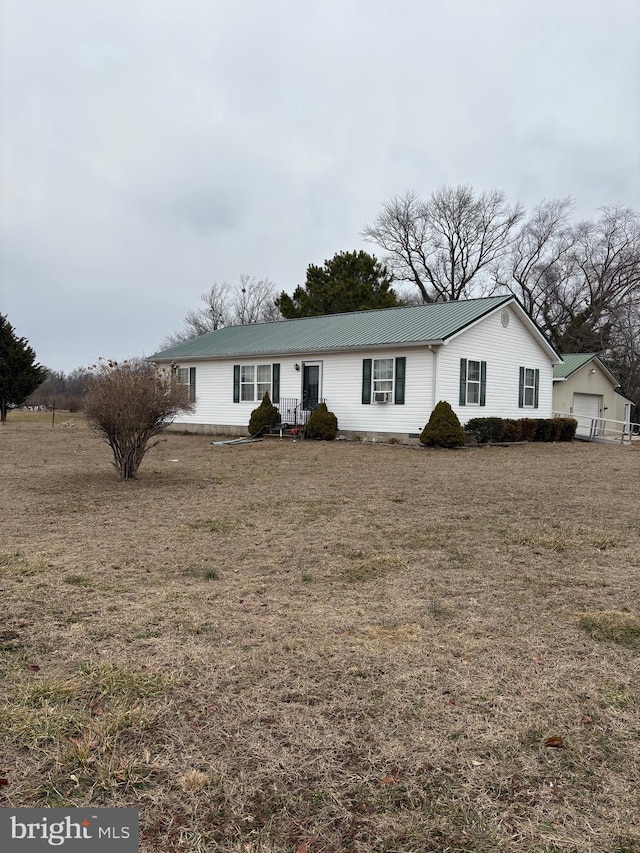 single story home with a detached garage, crawl space, metal roof, an outdoor structure, and a front lawn