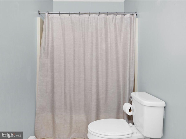 bathroom with a shower with curtain and toilet