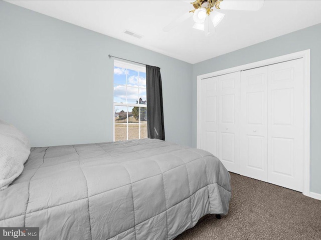 carpeted bedroom featuring a ceiling fan, visible vents, and a closet