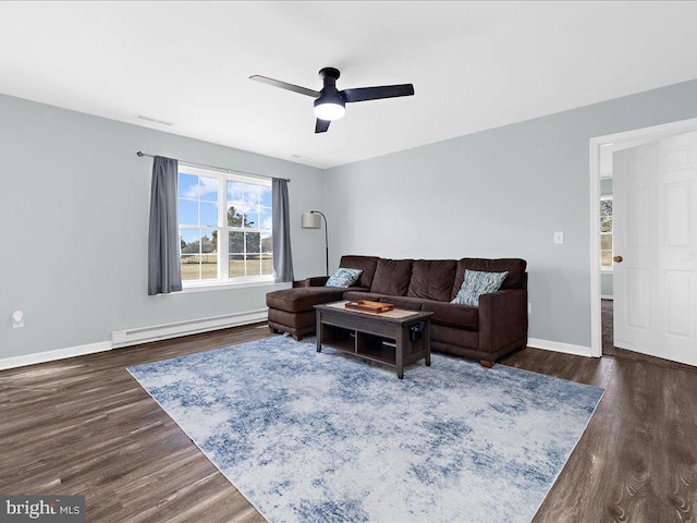 living room with dark wood-style floors, visible vents, a baseboard heating unit, ceiling fan, and baseboards