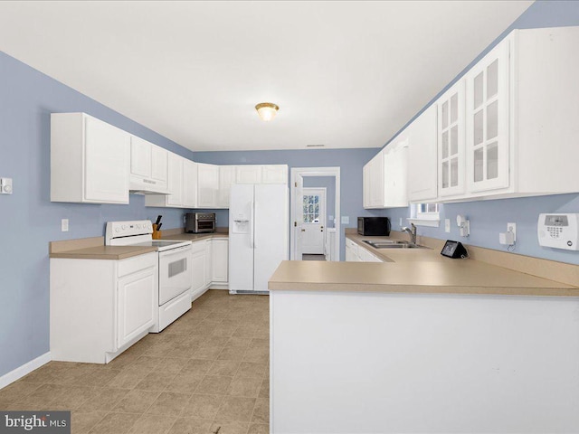 kitchen featuring glass insert cabinets, a sink, a peninsula, white appliances, and under cabinet range hood