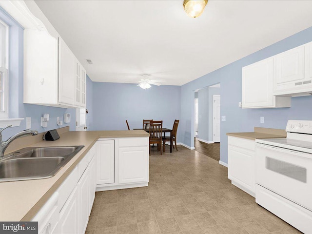 kitchen featuring under cabinet range hood, a peninsula, a sink, light countertops, and white range with electric stovetop