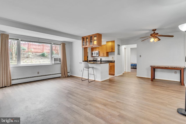 unfurnished living room featuring ceiling fan, light wood-type flooring, and a baseboard radiator