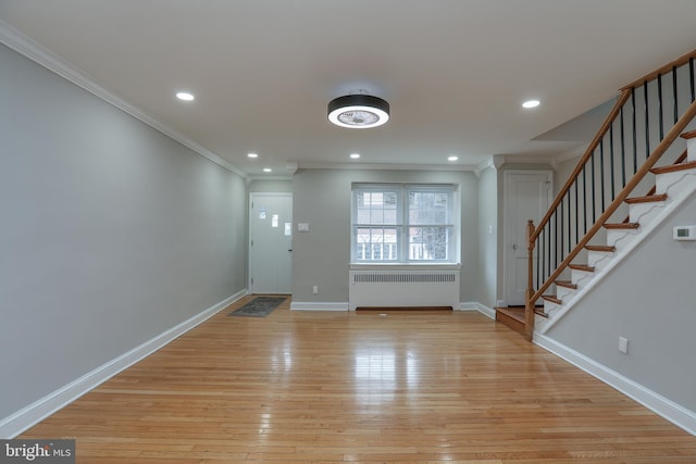 foyer featuring ornamental molding, radiator, and light hardwood / wood-style floors