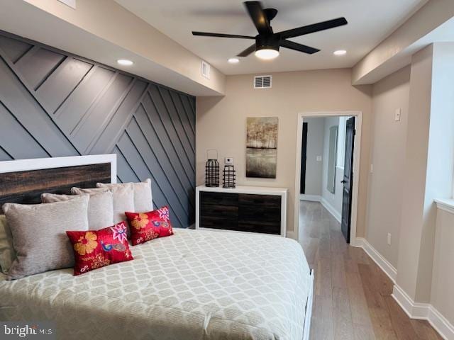 bedroom featuring visible vents, baseboards, wood finished floors, and recessed lighting